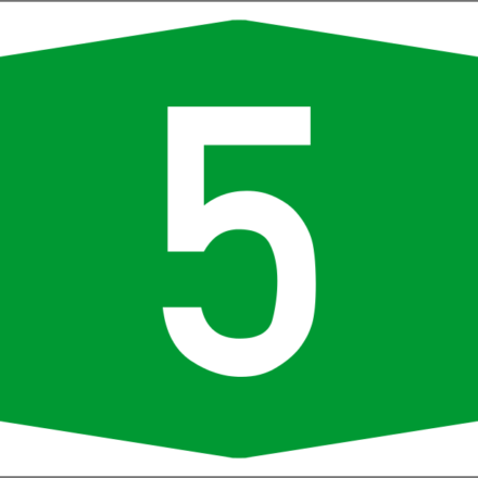 A Greek roadway sign for Autokinetodromos 5 is a white numeral 5 inside a green horizontally elongated hexagon