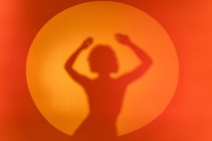 A color photo of a silhouette of a woman dancing.